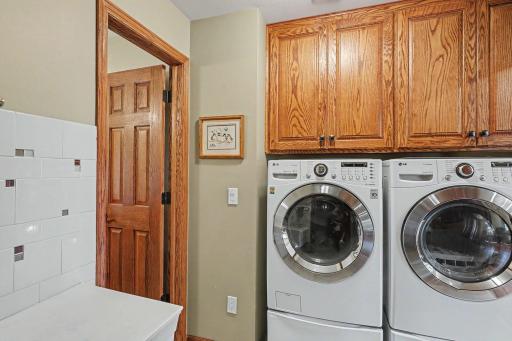 Convenient main floor laundry room with built-in cabinets, laundry sink as well as a coat and shoe closet.