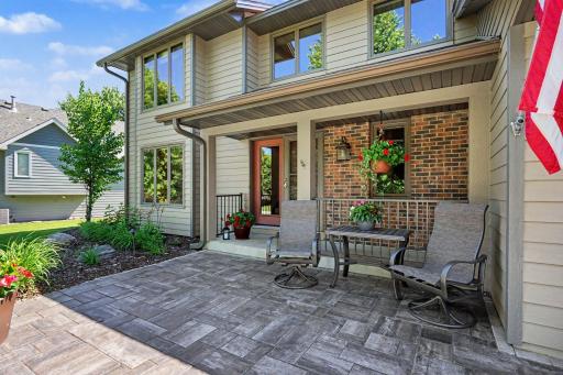 Inviting front patio with stone pavers and covered front porch.