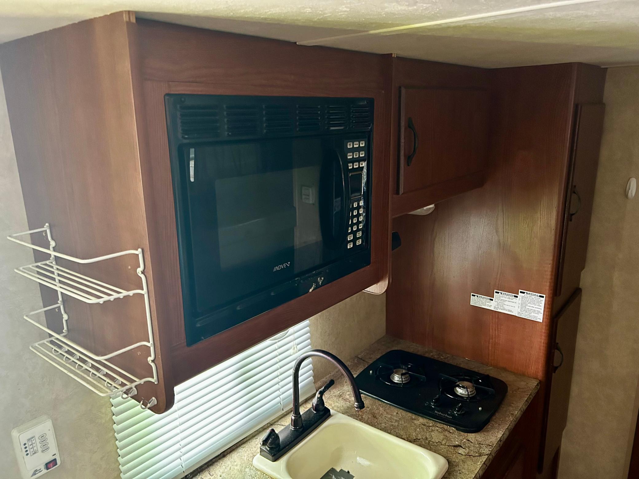 Camper Two - Eat-in kitchen with a small stove, sink, mini fridge, and microwave.
