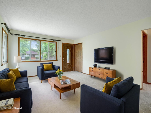 The front door of the home enters into a bright & sunny living room with brand new carpet.