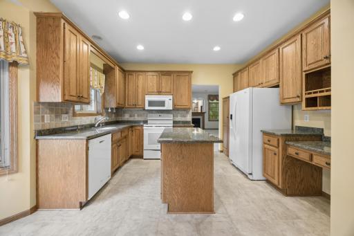 Kitchen has granite counters and planning desk.