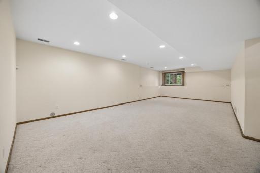 Lower level rec room with daylight windows and recessed lights.