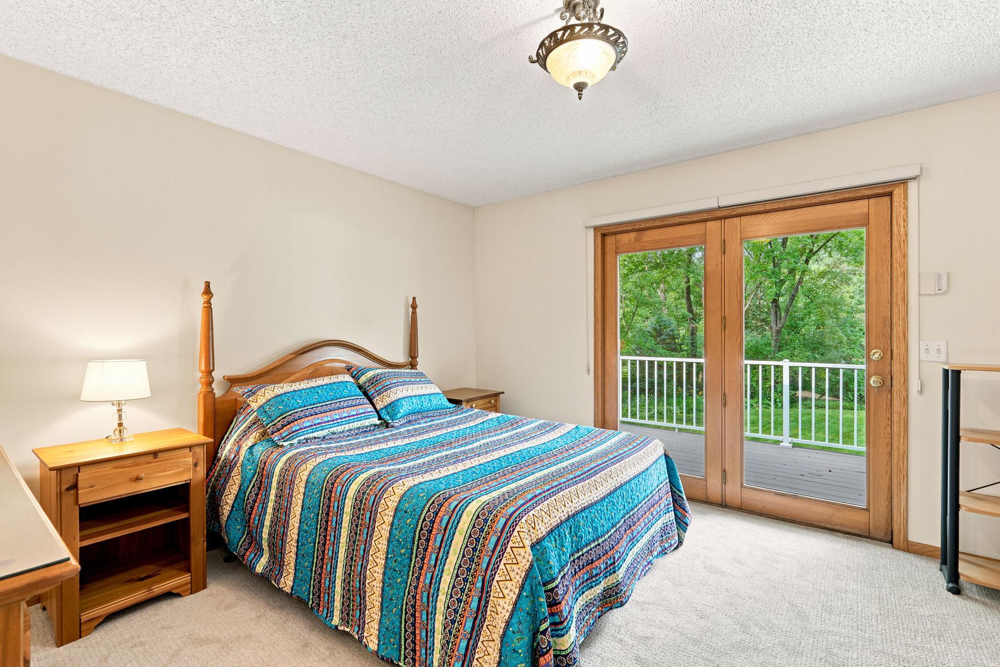 Primary bedroom has deck and large window panes to bring in natural light.
