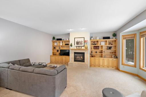 Large family room with custom built in shelving and gas fireplace