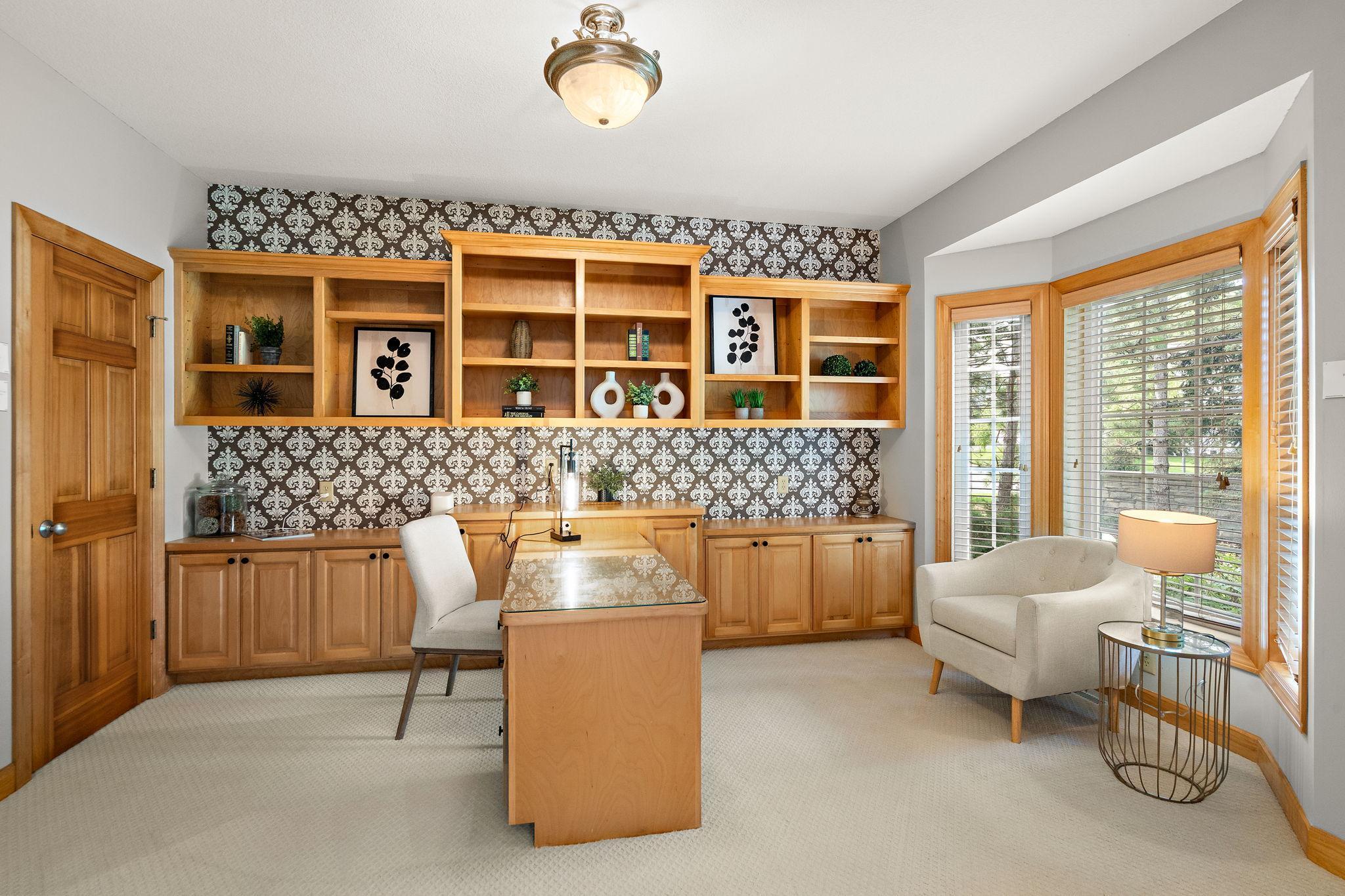 Large main floor office with double glass French doors and walk in closet - built in futon shelving and desk