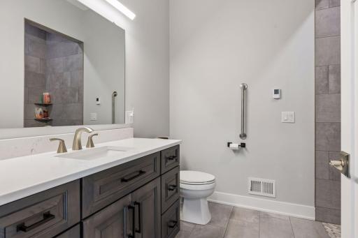 MIL suite private bathroom with 36" wide doors and grab bars and in floor electric heat.