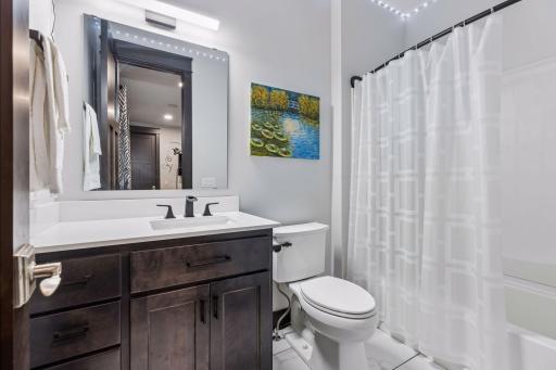 Quartz countertops, layered lighting in bathroom 3000k recessed light and 5000k lights above the mirror.