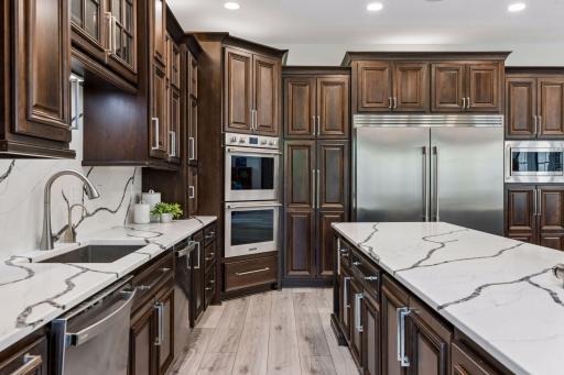 The back wall of the kitchen features a pantry, 2 dishwashers, sink, hot water dispenser, 2 appliance garages, pull-out garbage and recycling. 