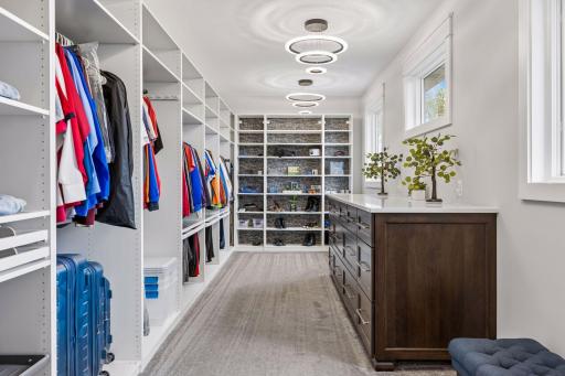 Primary suite walk-in closet - Features a quartz countertop on a built-in peninsula which has extra deep drawers of different sizes. 20 ft of closet space with additional shelving to showcase shoes.