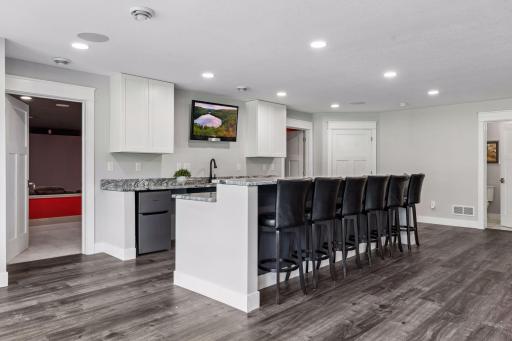 The kitchenette features 2 beverage fridges, dishwasher, hot water dispenser, garbage disposal and seating for 6 at the large island with a raised bar.