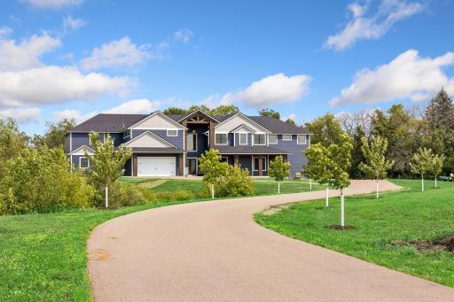 Maple trees align the winding driveway.