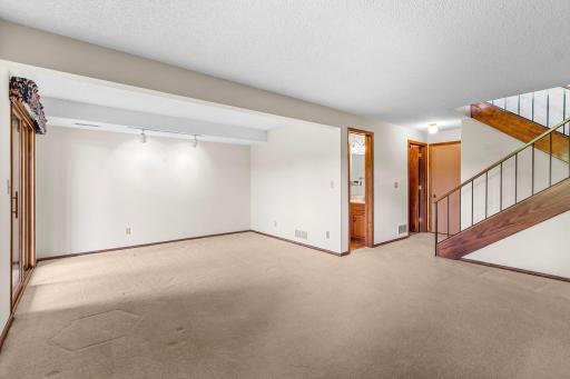 The lower level family room with a 3/4 bath and door to the attached 2 car garage.