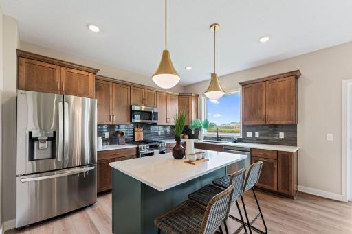 Wood perimeter cabinets with Quartz countertops and tile backsplash