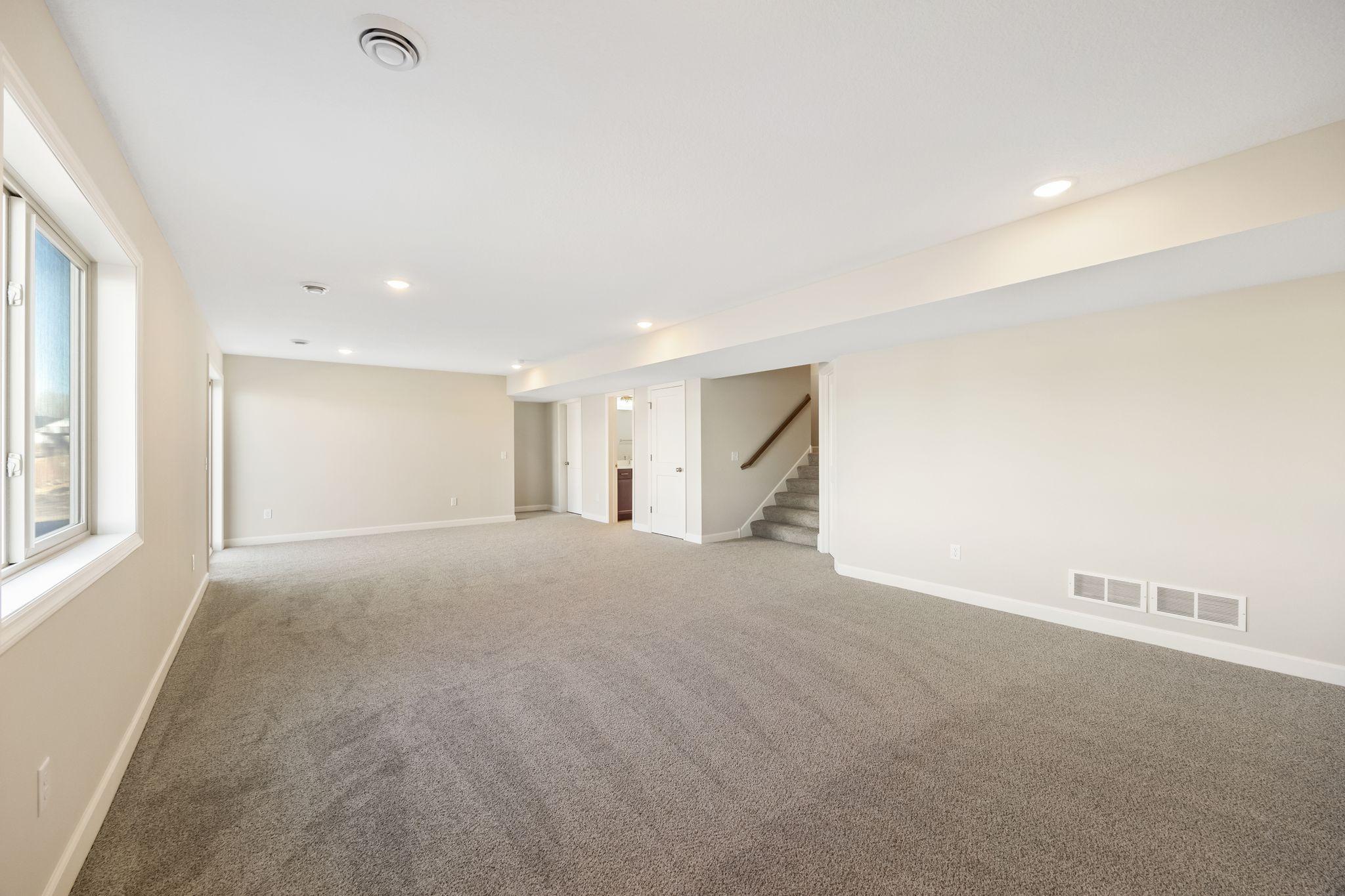 Finished lower level rec room with look-out windows for natural light - this photo is not this exact home, but one of the same floorplan