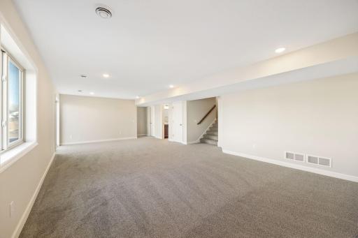 Finished lower level rec room with look-out windows for natural light - this photo is not this exact home, but one of the same floorplan