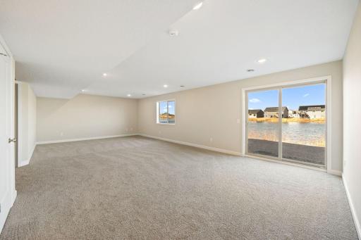 Finished lower level rec room - home for sale is not a walk-out. There will be 2 windows in this space and no sliding glass door - this photo is not this exact home, but one of the same floorplan