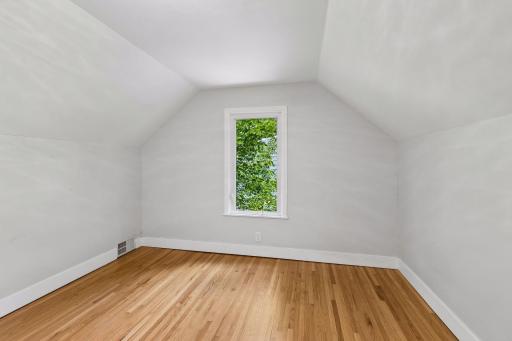 The upper level bedroom has white woodwork with a north facing window
