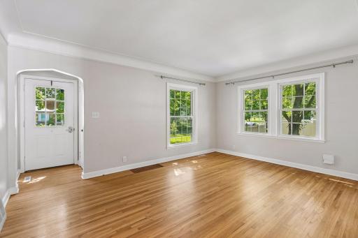 The living room has beautiful hardwood flooring and a sunny southern exposure