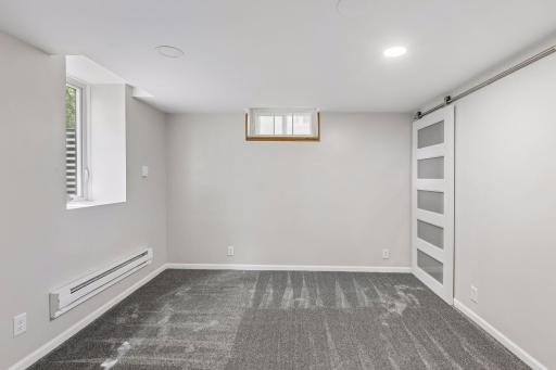 The lower level bedroom has an east facing window with a sliding barn door into the closet
