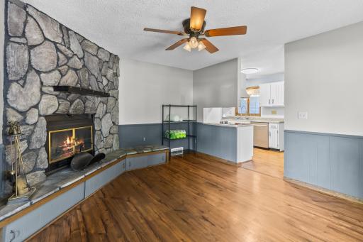 Cozy hearth room anchored by wood burning fireplace with stone surround.