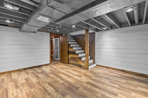 Lower level family room finished with LVP flooring and shiplap walls.