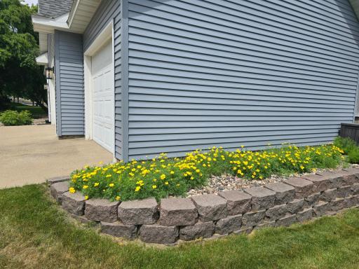 Great granite stone work and pretty flowers. Concrete triple driveway shows like new