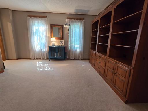 Carpeted living room has recently been enjoyed as a home theater room.