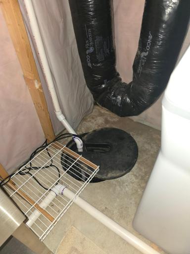 View of the home sump pump system that has an installed and functional pump. Basket never gets wet in case you are wondering.