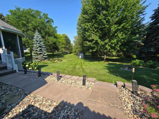 View of landscaped back yard from Spa area and door to the garage. Note the decorative washed stone sidewalk!