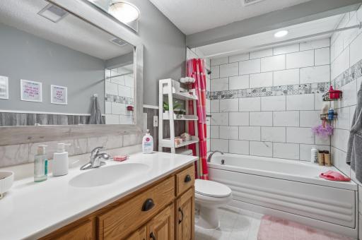 Lower level full bath with tile flooring and shower surround.