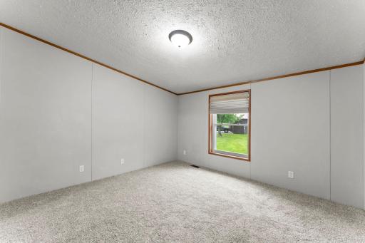 The primary bedroom features new carpeting and a vaulted ceiling.