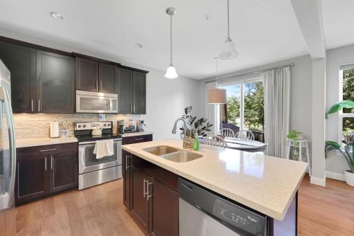 Oooooh, that kitchen! Center island with sink, granite counters, tile backsplash, stainless steel appliances, pantry, and it's part of a wide-open main level.