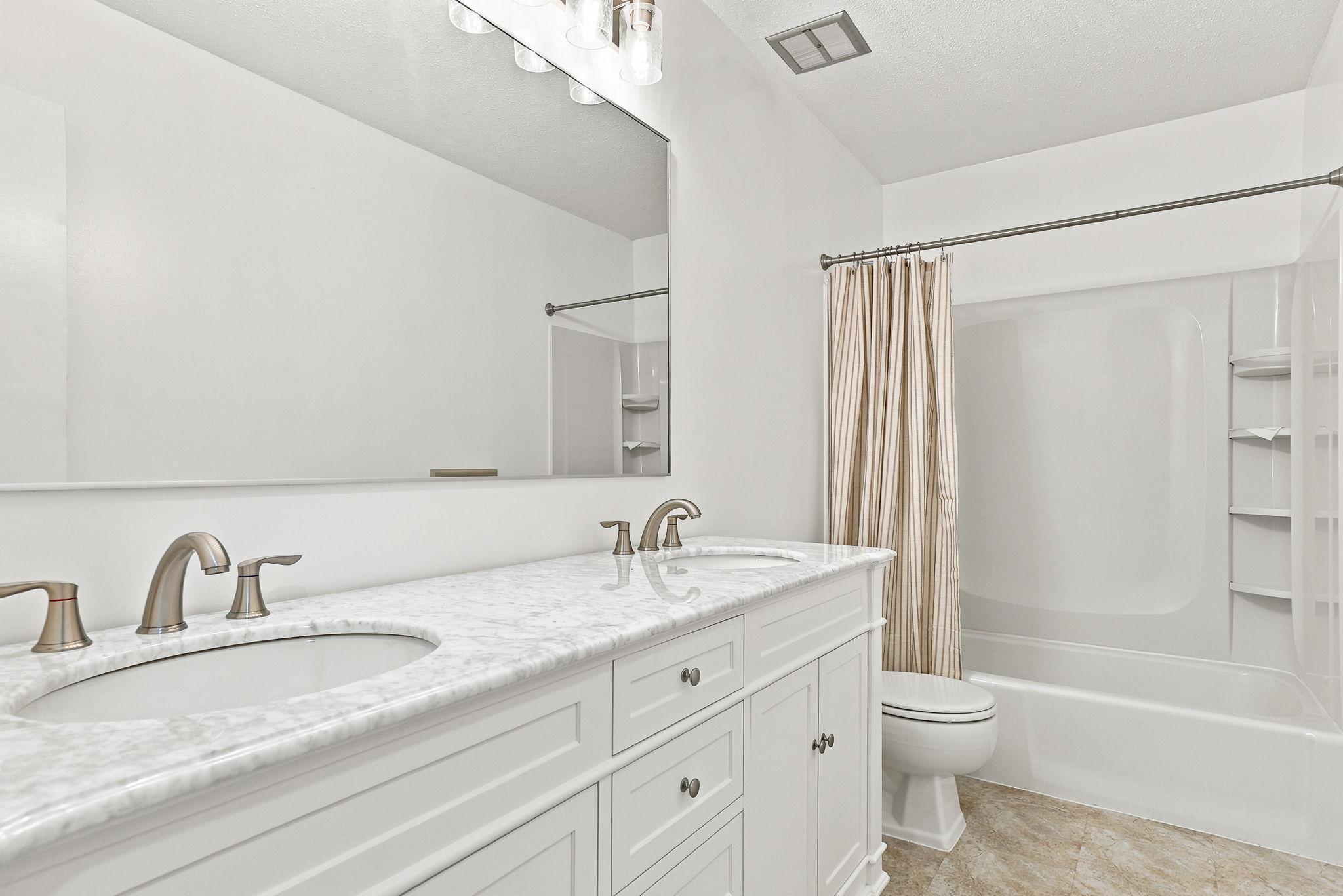 Full size bathroom with double sink on upper level