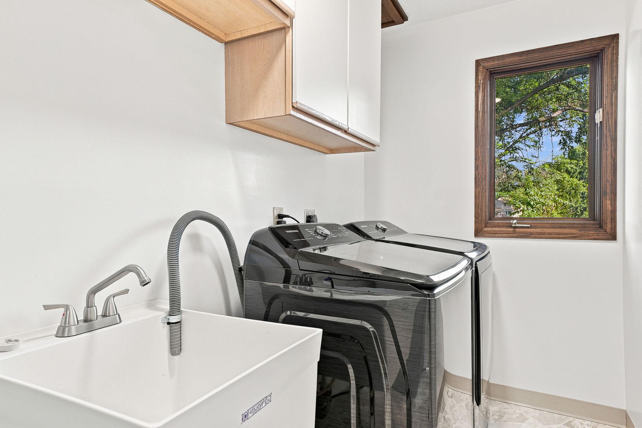 The laundry room has been updated with a newer washer and dryer