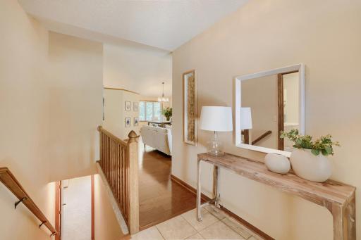 Step inside & you'll immediately appreciate the bright, open foyer that creates a warm & inviting first impression. The tiled entryway offers both style & durability, while soaring vaulted ceilings & hdwd floors draw your eye into the main lvl living