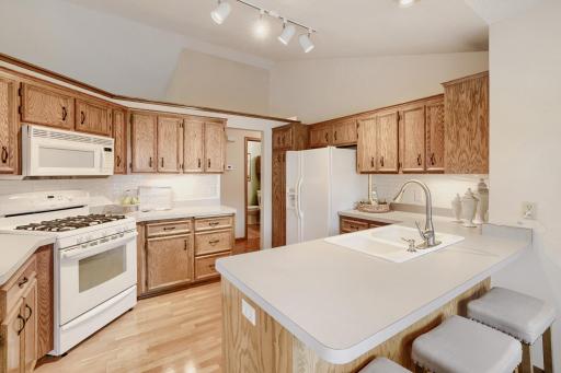The kitchen also features a gas range, generous counter space, and under-cabinet lighting. Warm finishes, soaring ceilings, and an abundance of natural light create a welcoming atmosphere that truly makes this kitchen the heart of the home.