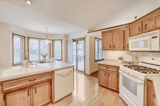 The spacious eat-in kitchen is designed to be the heart of the home, combining functionality with a bright, welcoming atmosphere. Abundant oak cabinetry provides exceptional storage, with expansive countertops & breakfast bar