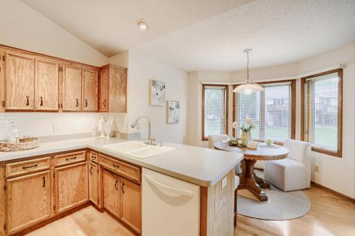 A sunny bayed dinette is surrounded by windows, filling the space with natural light and creating the perfect spot to enjoy your morning coffee while overlooking the private backyard. The open layout keeps everyone connected