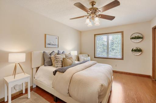 Located on the main level, this inviting primary bedroom makes everyday living effortless. This generous bedroom offers plenty of room for a king-size bed & additional furnishings while warm hrdwd floors & large windows create a peaceful atmosphere