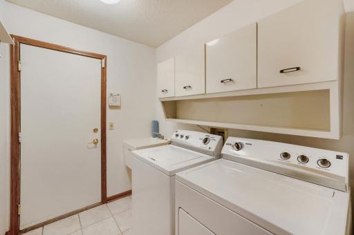 Enjoy the convenience of main-level laundry, making everyday living easy & eliminating the need to carry laundry up & down stairs. The laundry room & mudroom offers a full-size washer & dryer, abundant overhead cabinetry for storage, + a utility sink