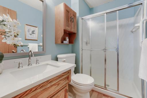 The private primary bath is thoughtfully designed to offer comfort and convenience, making it the perfect complement to the spacious main-level primary suite. Featuring a large vanity with ample countertop space and storage