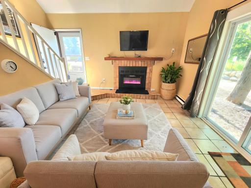 The living room area features glass doors to your patio and attractive electric fireplace insert.(virtually staged)