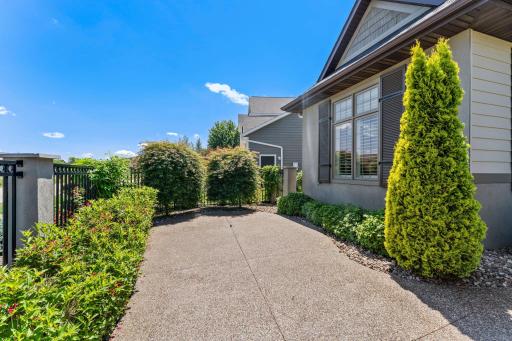 Front courtyard is lined with carefully placed shrubbery, creating a welcoming sense of arrival while enhancing privacy and softening the homeâs exterior.