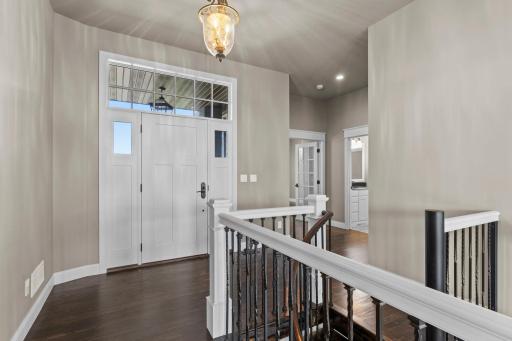 A welcoming foyer opens into a spacious, open floor plan filled with natural light, offering a seamless flow between living spaces and an immediate sense of openness and comfort.
