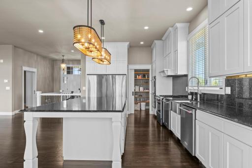 Custom cabinetry and lighting, paired with granite countertops and backsplash, create a cohesive and refined design.