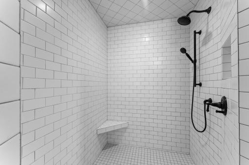 A floor-to-ceiling ceramic tile shower creates a clean, continuous finish that enhances the sense of height and luxury