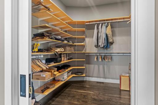 Primary walk-in closet with pocket door and maple shelving and motion activated lighting in all closets