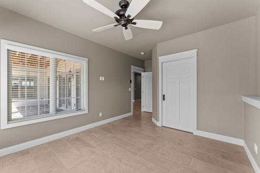 Lower-level bedroom 2 with additional heating system, pocket door and motion activated lighting in the closet.