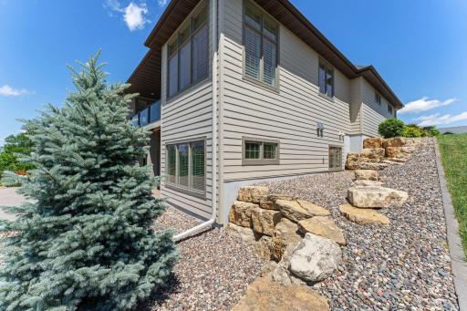 Side of home with cascading limestone and river rock