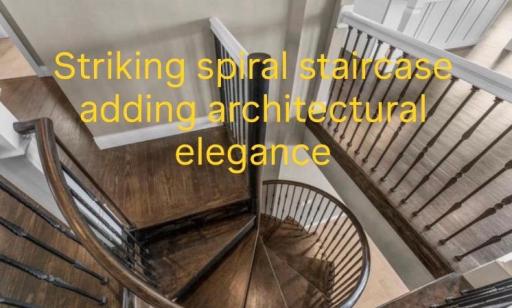 A striking spiral staircase with wrought steel balusters connects the main floor to the lower level, adding architectural elegance and visual interest.
